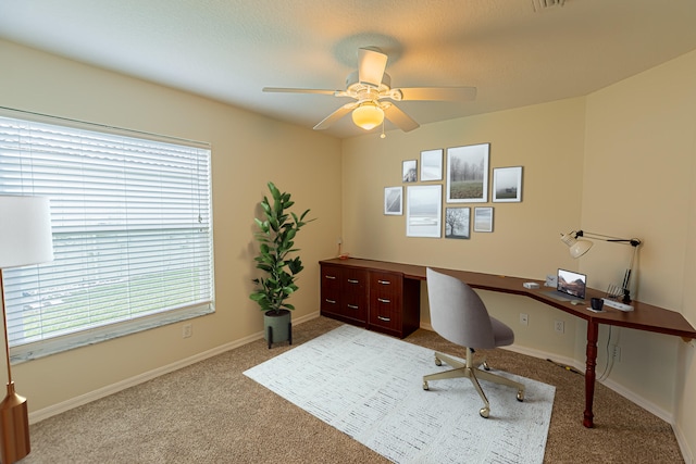 carpeted office featuring ceiling fan