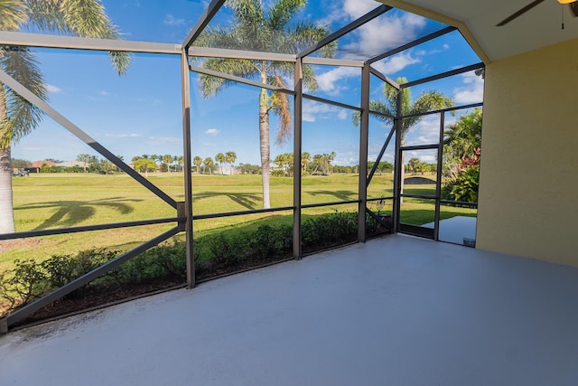 unfurnished sunroom featuring ceiling fan