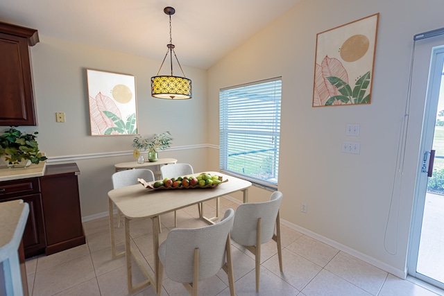 dining room with lofted ceiling and light tile patterned floors