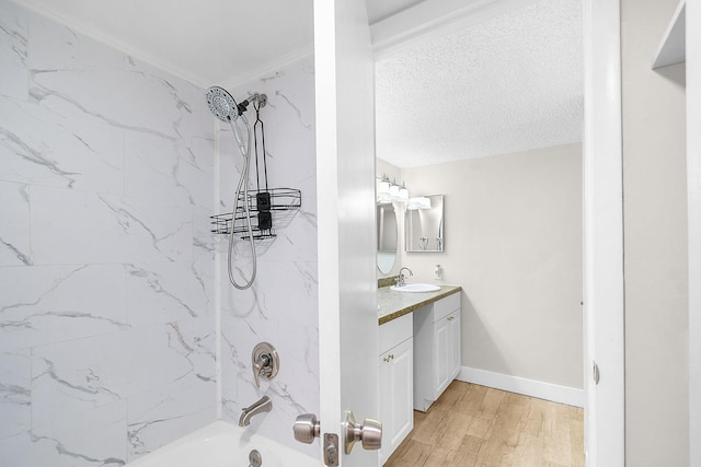 bathroom with vanity, wood-type flooring, and tiled shower / bath combo