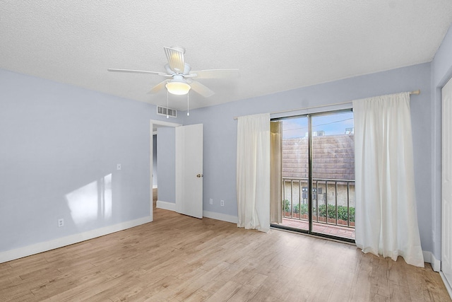 unfurnished room with ceiling fan, a textured ceiling, and light wood-type flooring