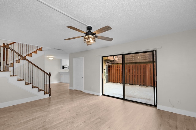 spare room featuring ceiling fan, light hardwood / wood-style flooring, and a textured ceiling