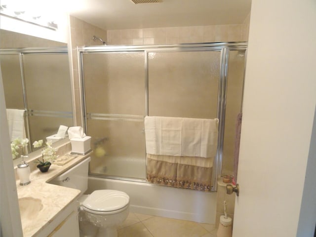 full bathroom featuring tile patterned floors, vanity, toilet, and enclosed tub / shower combo