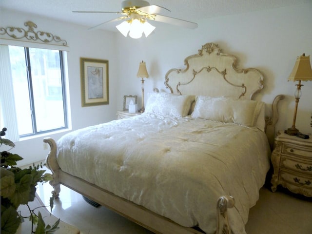 tiled bedroom featuring ceiling fan