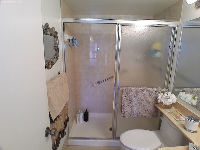 bathroom featuring toilet and a shower with door