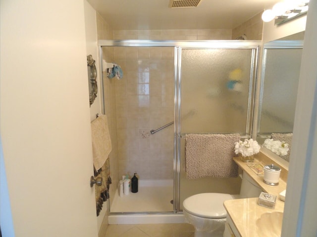 bathroom with tile patterned floors, vanity, toilet, and a shower with door