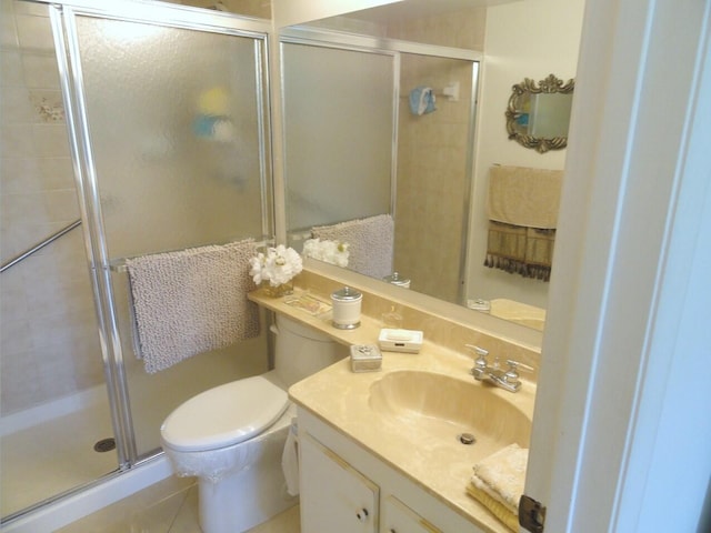 bathroom with toilet, vanity, tile patterned floors, and a shower with shower door