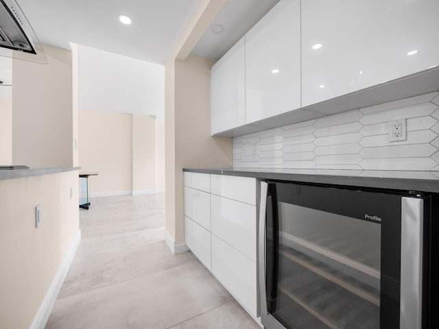 bar featuring white cabinets, decorative backsplash, and beverage cooler