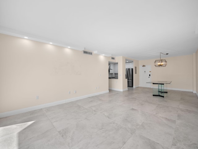 unfurnished living room with an inviting chandelier