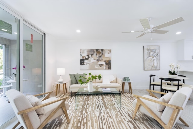 living room with hardwood / wood-style floors, ceiling fan, and crown molding