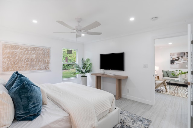 bedroom with ceiling fan, crown molding, and light hardwood / wood-style flooring