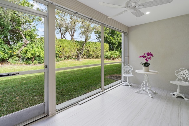 unfurnished sunroom featuring ceiling fan