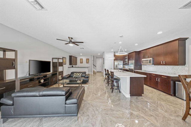 living room with a textured ceiling, ceiling fan, and sink