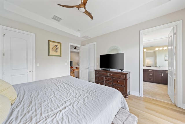 bedroom featuring connected bathroom, ceiling fan, sink, and light hardwood / wood-style floors