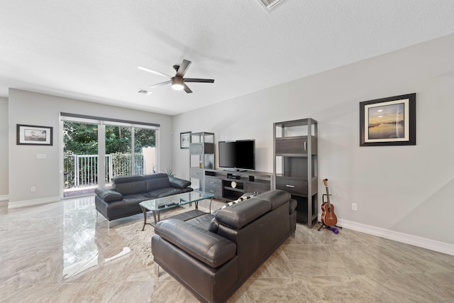 living room with a textured ceiling and ceiling fan