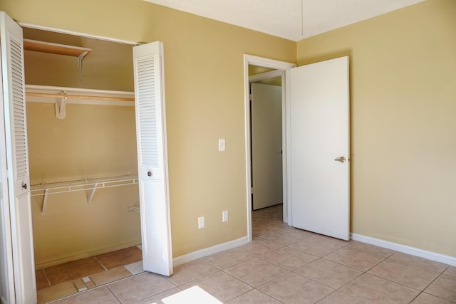 unfurnished bedroom with light tile patterned floors and a closet