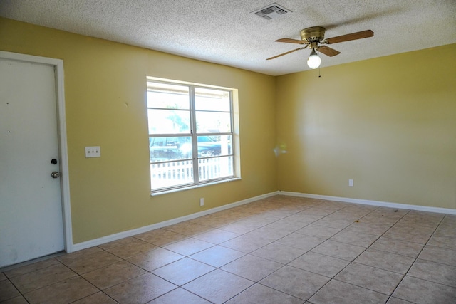 spare room with light tile patterned floors, a textured ceiling, and ceiling fan