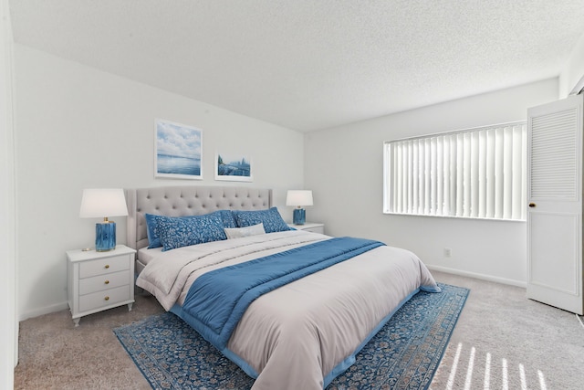 bedroom featuring a textured ceiling and light carpet