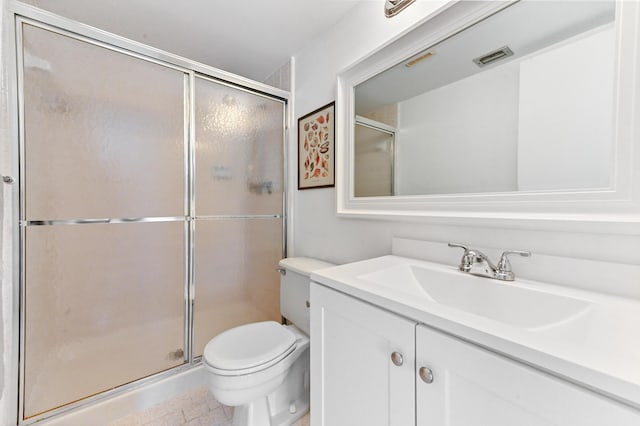 bathroom with a shower with door, vanity, and toilet