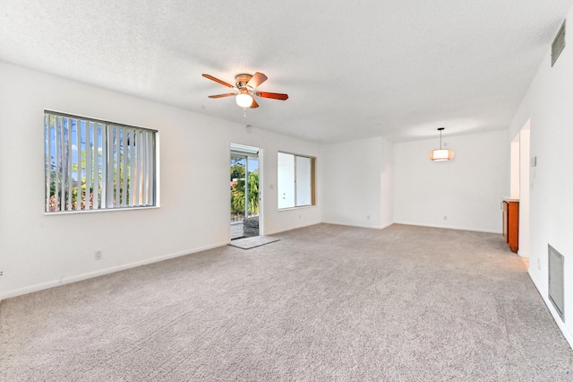 unfurnished living room with a textured ceiling, light colored carpet, and ceiling fan