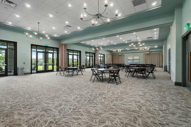 dining room featuring french doors, carpet flooring, and an inviting chandelier