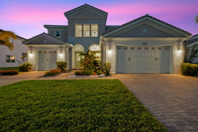 view of front of home featuring a garage and a yard