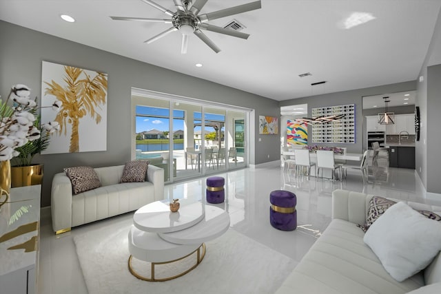 living room featuring sink, ceiling fan, and a water view