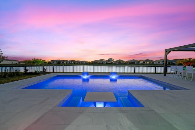 pool at dusk featuring a patio