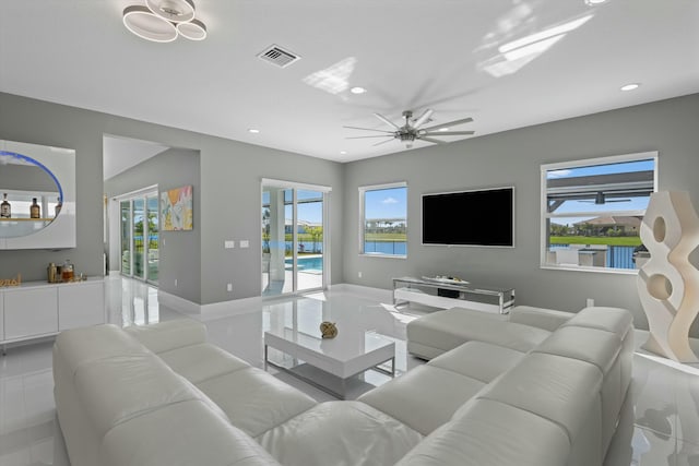 living room with ceiling fan, bar, and a wealth of natural light