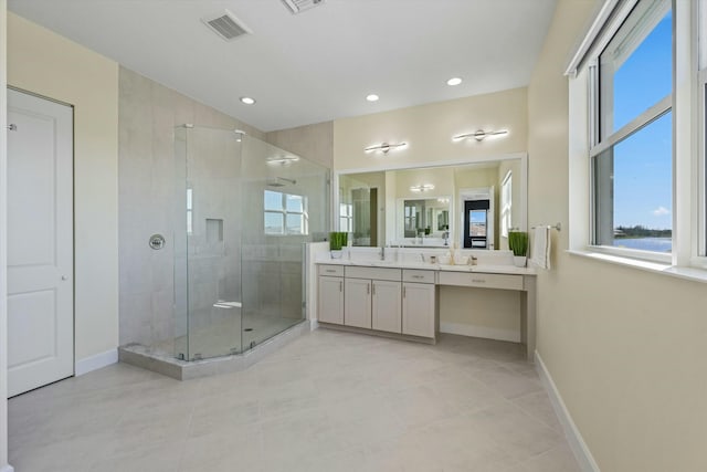 bathroom with tile patterned floors, vanity, and a shower with door