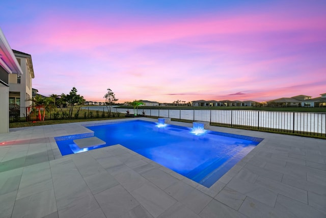 pool at dusk with a patio area