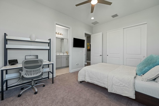 bedroom featuring ceiling fan, light colored carpet, ensuite bath, and a closet