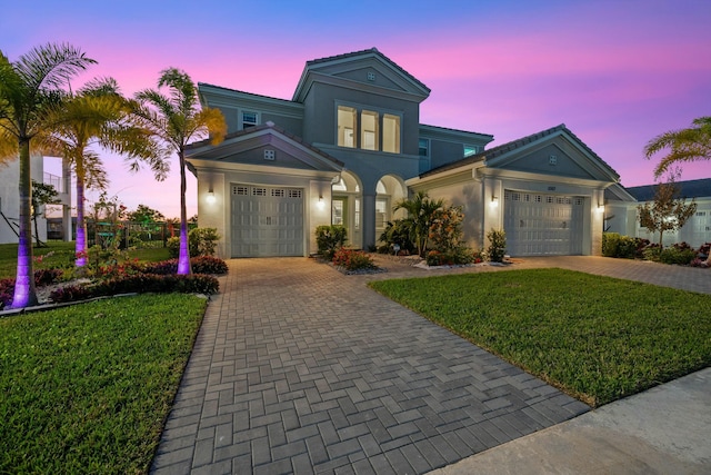 view of front of home with a garage and a yard