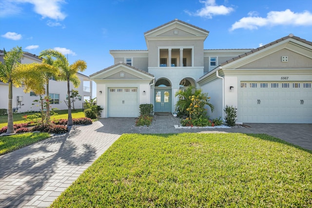 view of front of home featuring a garage, a front lawn, and french doors