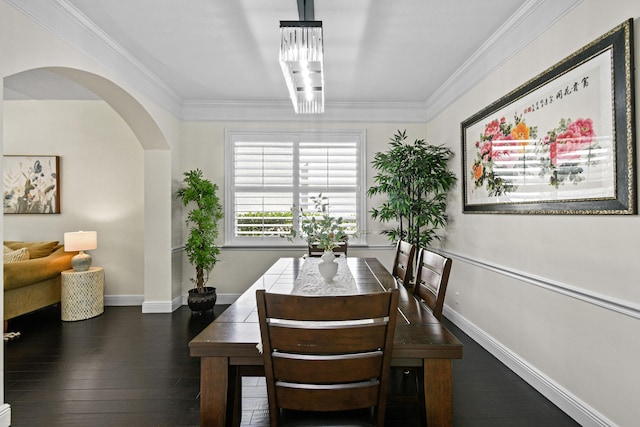 dining area featuring dark hardwood / wood-style floors, crown molding, and a notable chandelier