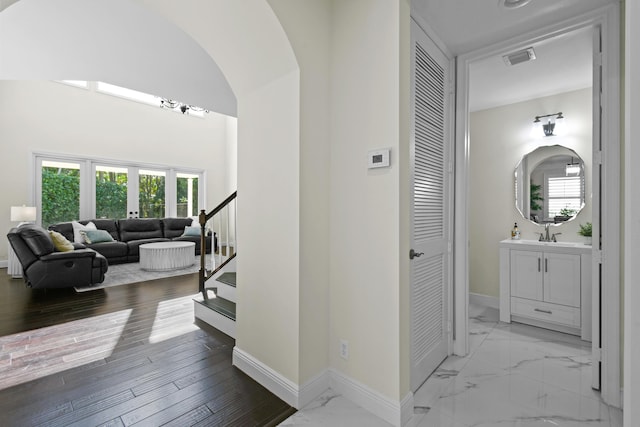 hallway with french doors, sink, and light hardwood / wood-style flooring