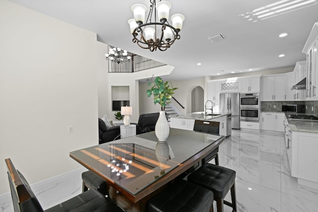 dining area featuring sink and an inviting chandelier