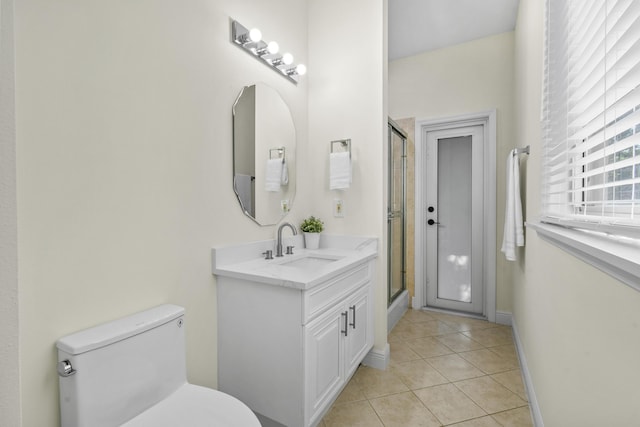 bathroom with tile patterned flooring, vanity, toilet, and a shower with shower door