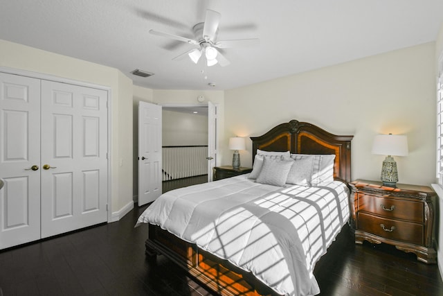 bedroom featuring ceiling fan, dark hardwood / wood-style floors, and a closet