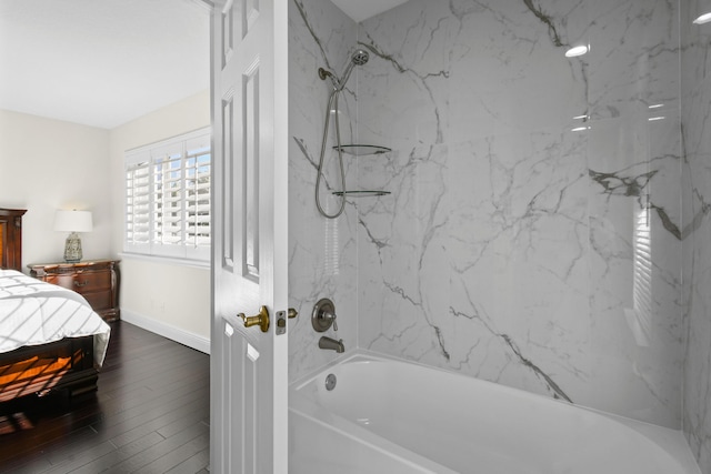 bathroom featuring wood-type flooring and tiled shower / bath