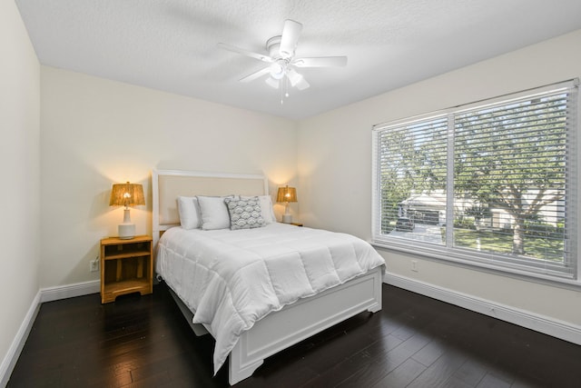 bedroom featuring a textured ceiling, dark hardwood / wood-style floors, and ceiling fan