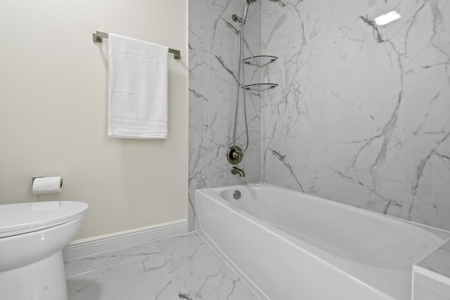 bathroom featuring tiled shower / bath combo and toilet