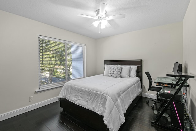 bedroom with a textured ceiling, ceiling fan, and dark wood-type flooring