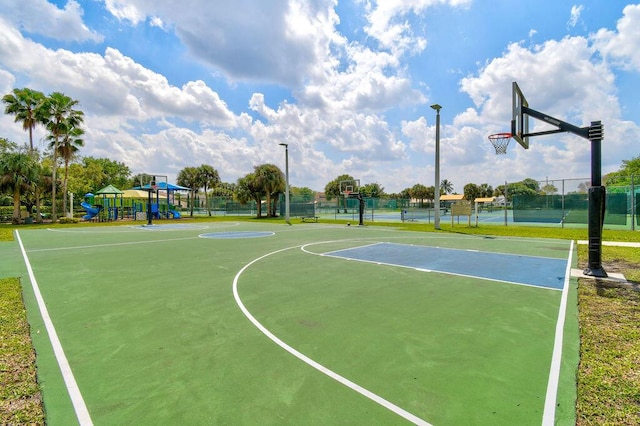 view of sport court featuring tennis court and a playground