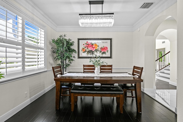 dining room with dark hardwood / wood-style flooring, ornamental molding, and a notable chandelier