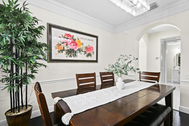 dining room with ornamental molding and dark wood-type flooring