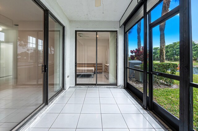 bedroom with access to exterior, ceiling fan, light tile patterned floors, and a textured ceiling