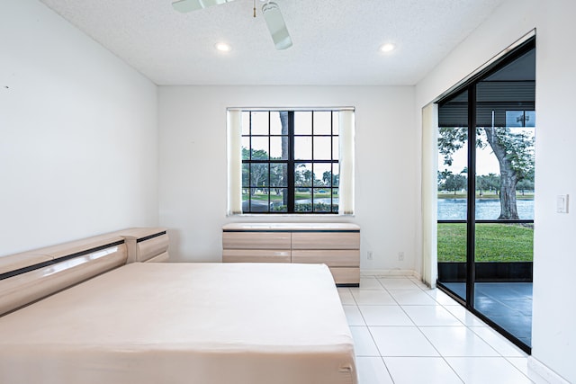 tiled bedroom featuring ceiling fan and a textured ceiling