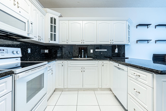 kitchen featuring a kitchen bar, kitchen peninsula, backsplash, white appliances, and white cabinets