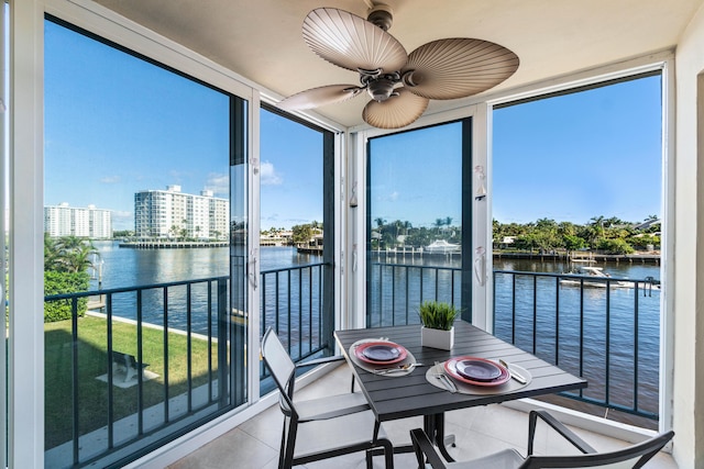 sunroom with a water view and ceiling fan